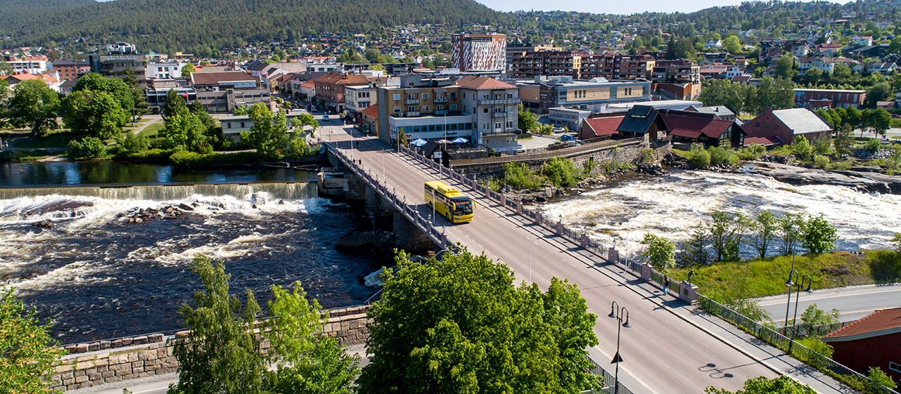 Dronebilde av buss som kjører over brua i Kongsberg.