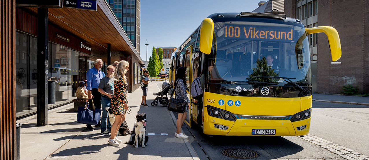 Bilde av passasjerer som går om bord på bussen på Drammen busstasjon.