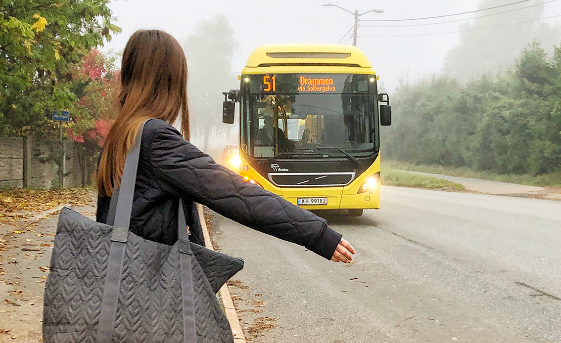 Bilde av jente som rekker ut hånda for å ta buss.