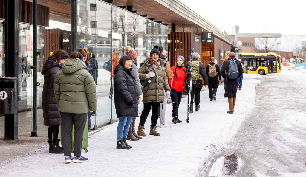 Bilde av folk som venter på bussen på Drammen busstasjon en vinterdag.