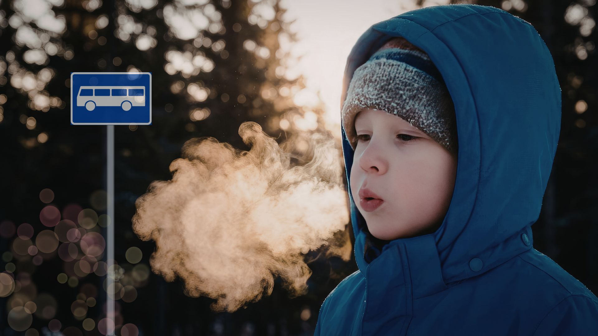 Gutt som blåser kaldt røyk ved et busstopp.
